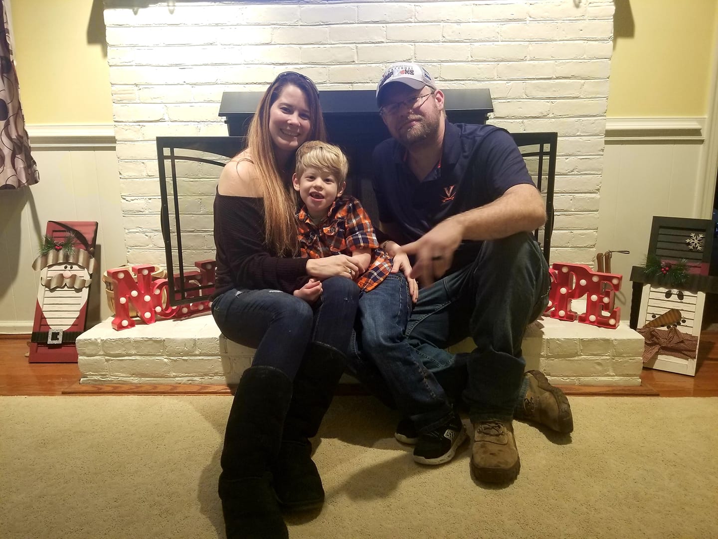 FME Family Bethany Sizemore, husband and son in front of fireplace